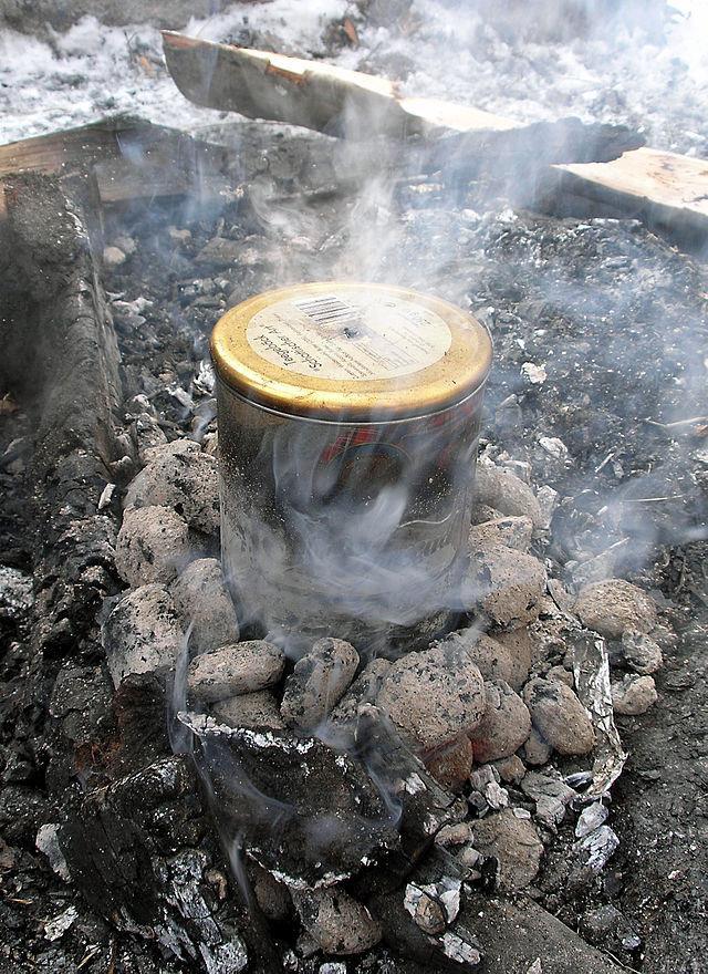 Eine geschlossene Blechdose in einem Glutnest