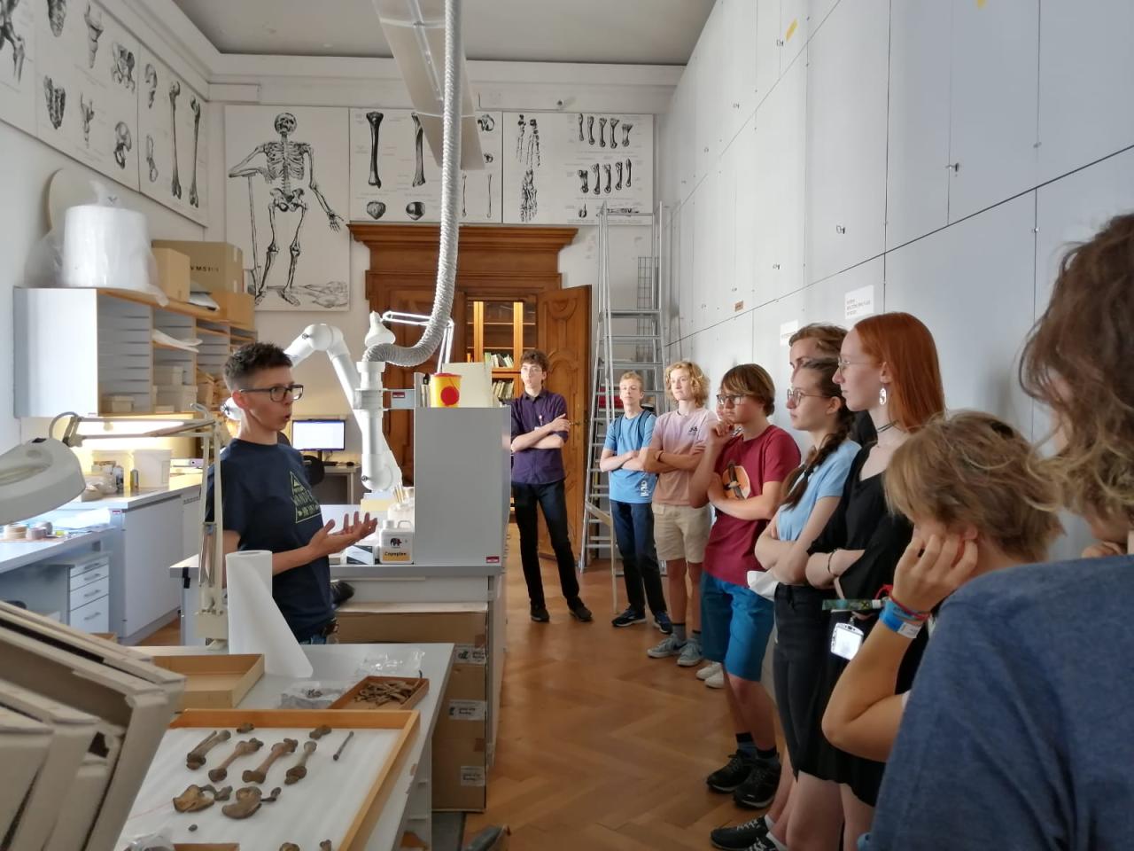 Eine Gruppe von Personen steht in einem Arbeitszimmer der anthropologischen Abteilung