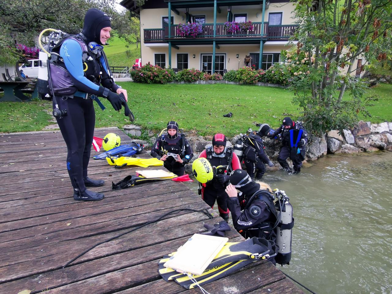 Eine Gruppe von Taucher:Innen beim Ausstieg aus dem See auf einen Steg