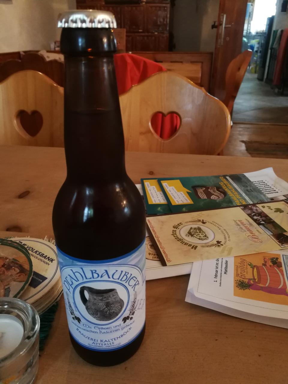 Eine Flasche Bier steht auf einem Tisch mit Flyern