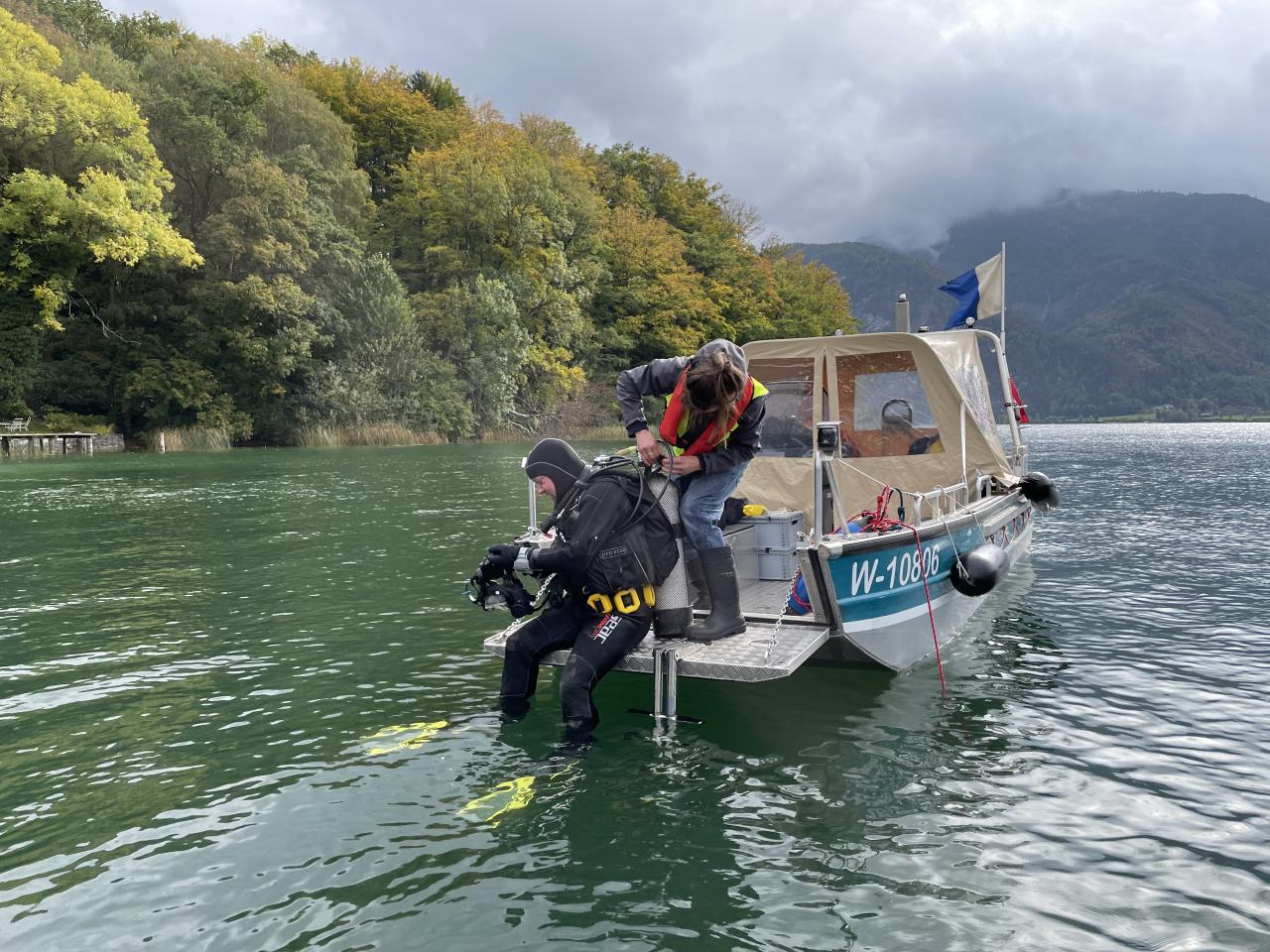 Taucher:Innen beim Einstieg ins Wasser vom Boot