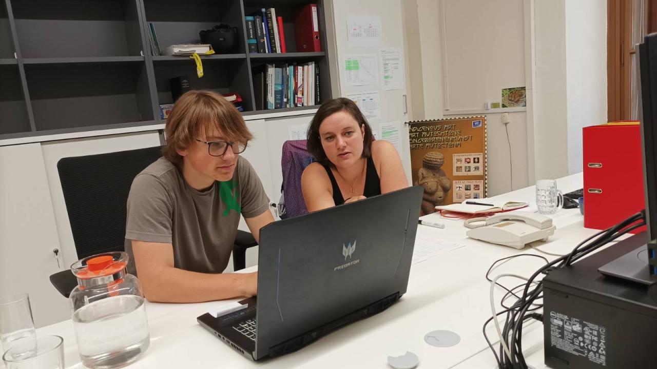 Anton Bernotat und Caroline Posch sitzen vor einem Laptop