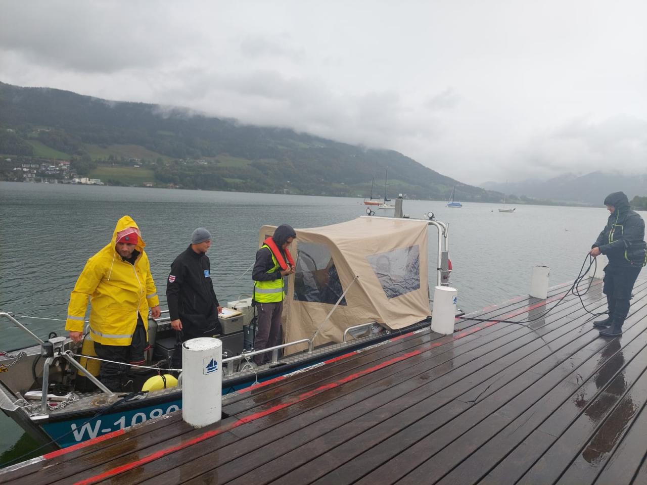Mehrere Personen steigen auf ein Boot am See