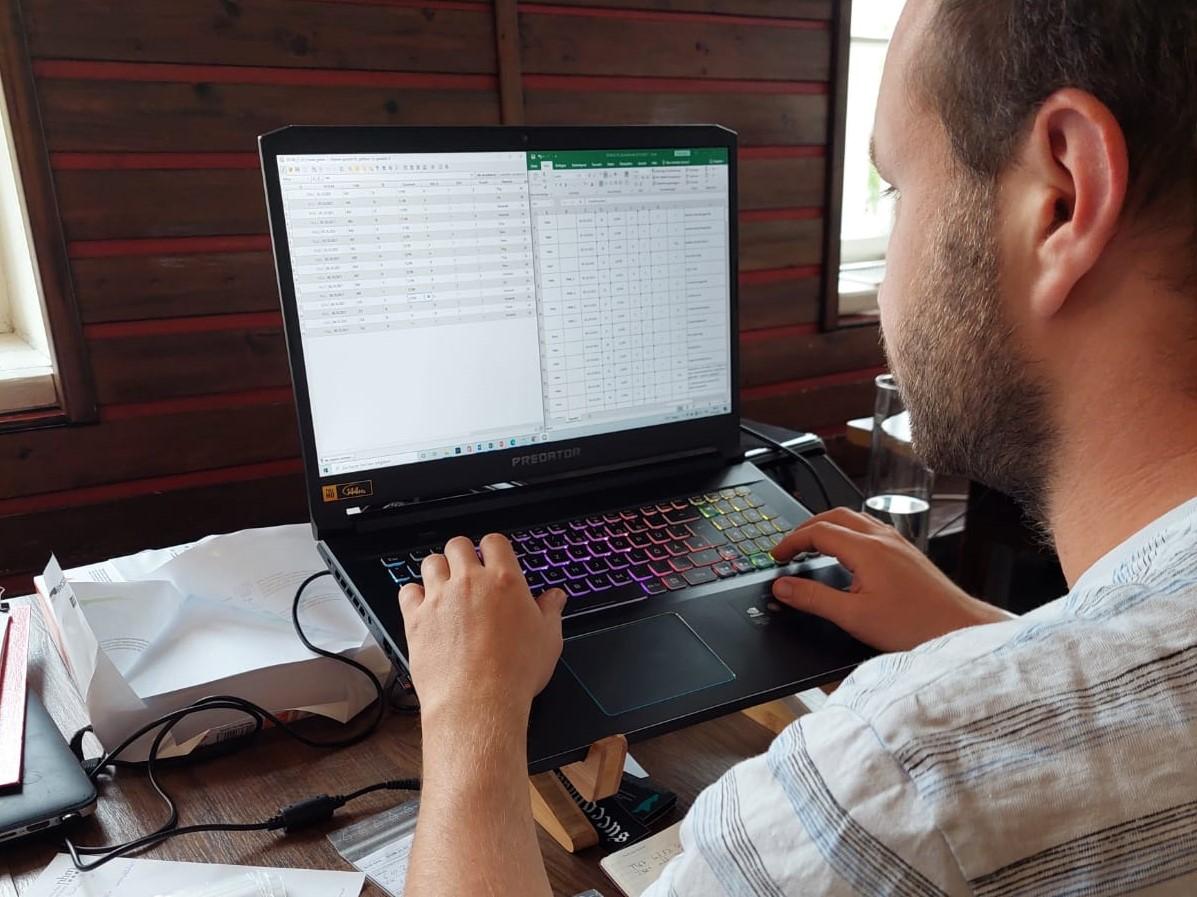 Eine Person sitzt vor einem Laptop und bearbeitet eine Tabelle