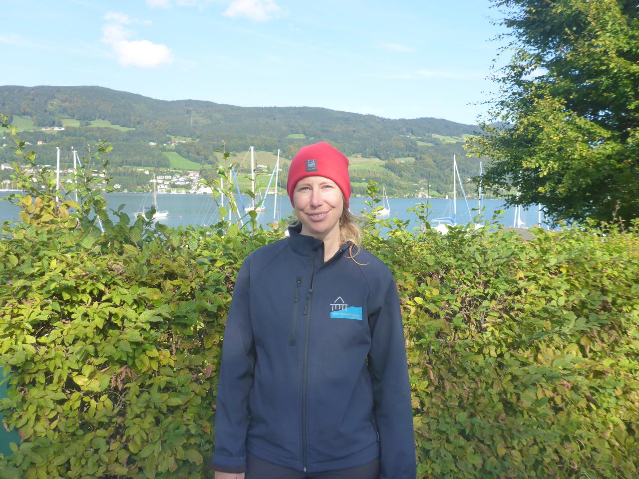 Esther Unterweger vor dem See mit einer roten Mütze