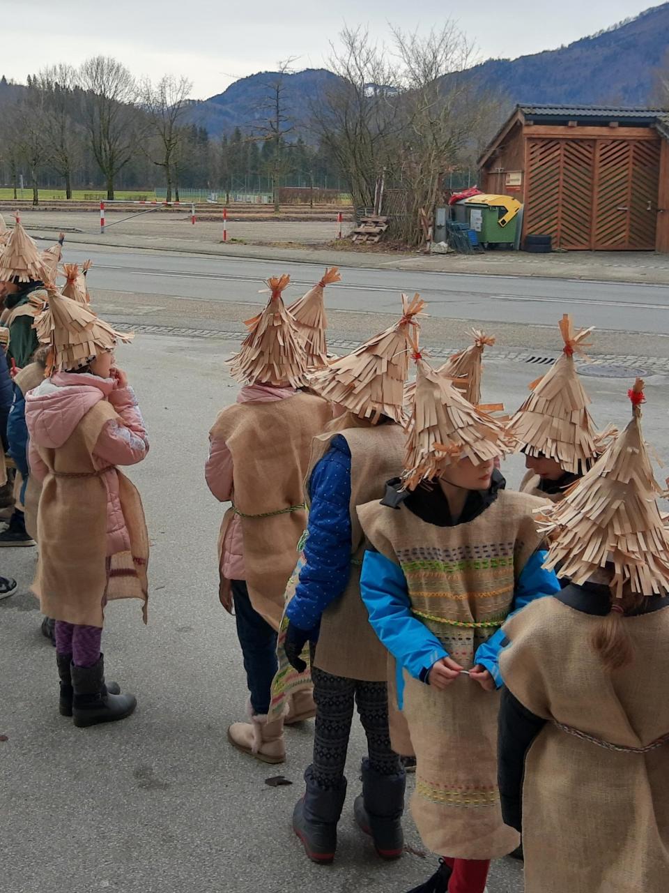Kinder auf einem Betonplatz in braunen Jutekostümen