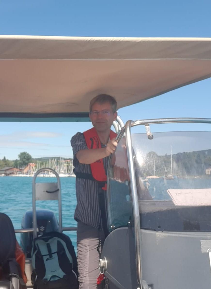 Henrik Pohl am Steuer eines Motorbootes auf dem See