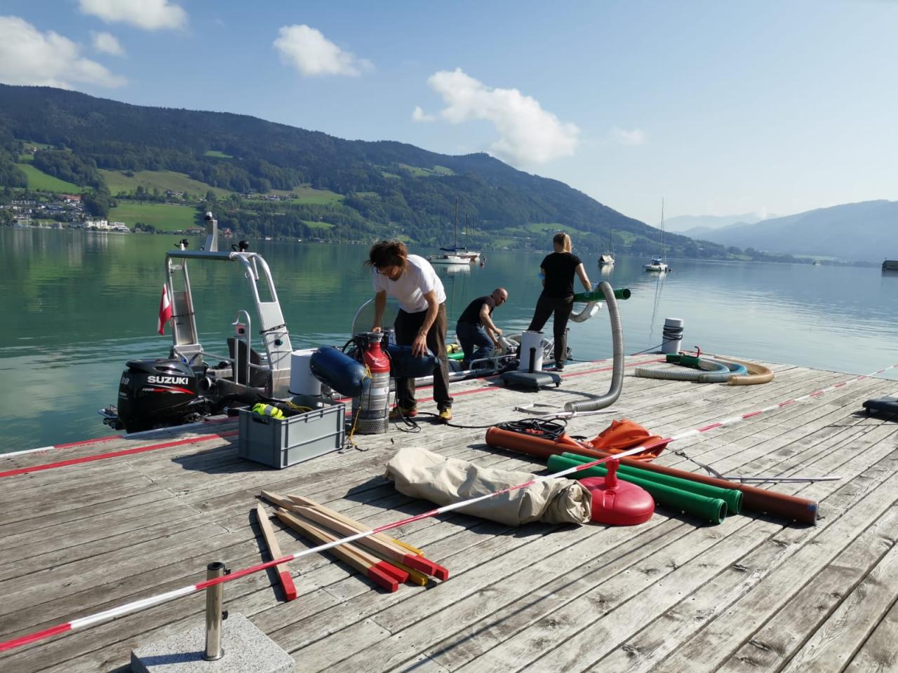 Mehrere Personen auf einem Steg beim Aufbau von Zelten