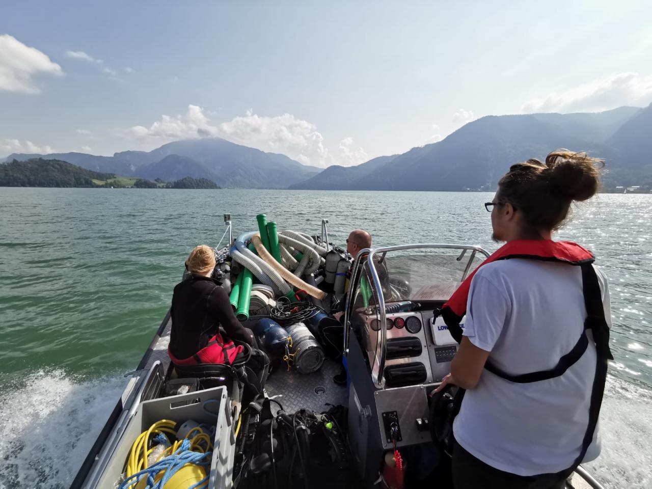Mehrere Personen auf einem Motorboot am See