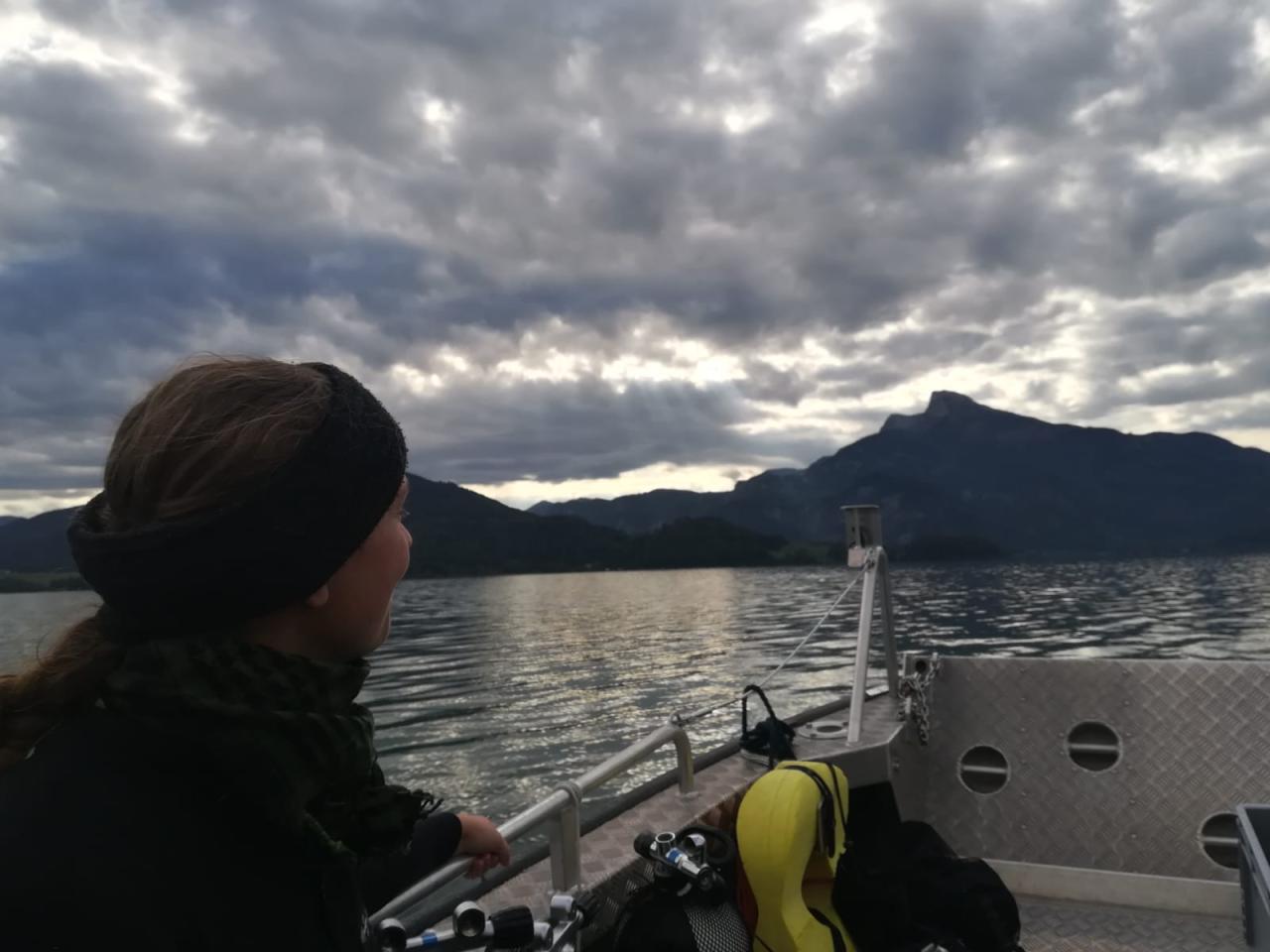 Eine Frau auf einem Boot am See, die Stimmung wirkt düster