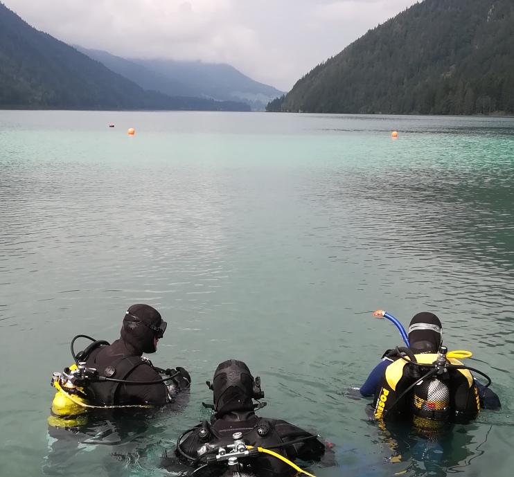 3 Taucher halb im Wasser des Weissensees
