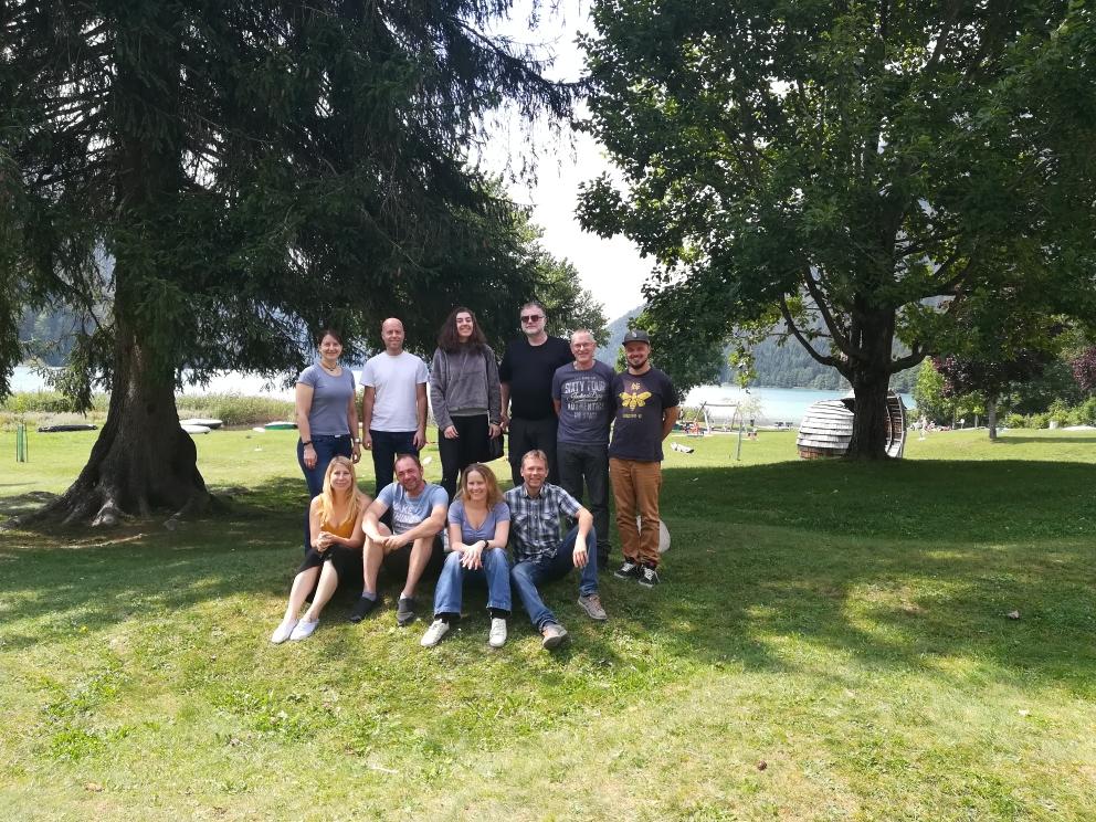 Eine Gruppe von mehreren Personen auf einer Wiese vor Bäumen