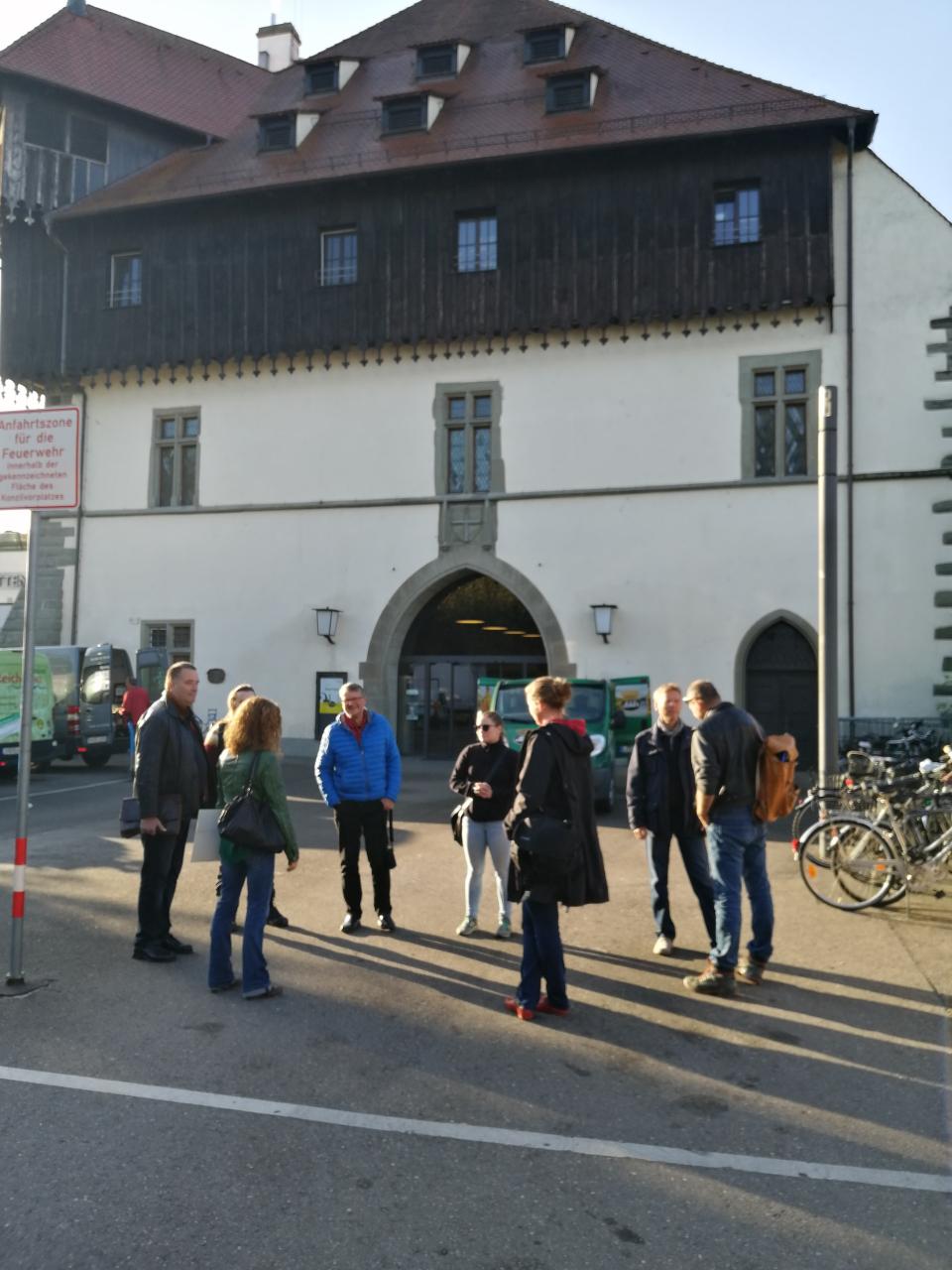 Eine Personengruppe vor einem weißen Gebäude in Konstanz