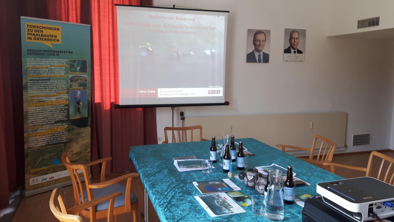 Ein Besprechungsraum mit gedecktem Tisch und einer Leinwand für die Präsentation