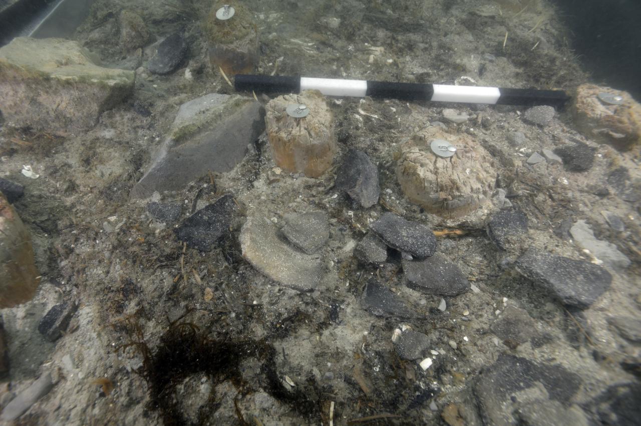 Der nördliche Grabungsschnitt unter Wasser, mit Maßstab und Keramikfragmenten