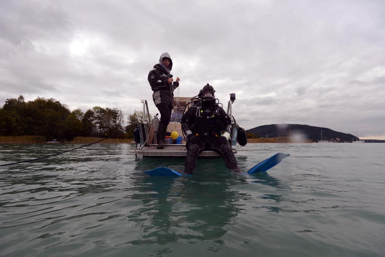 Ein Taucher kurz vor dem Einstieg aus dem Boot ins Wasser, eine 2. Person unterstützt ihn dabei