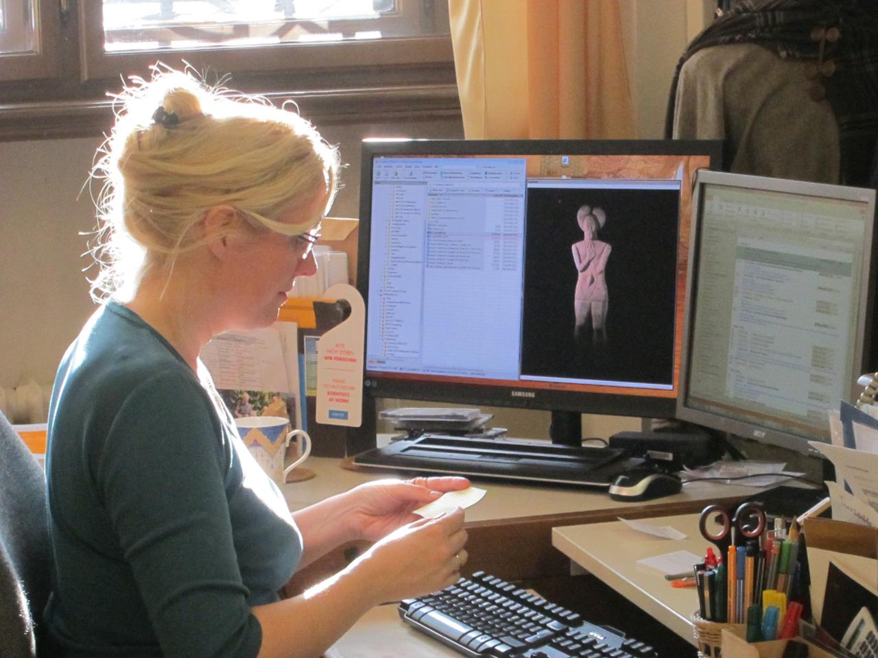 Karina Grömer an der Textilstation vor einem Computerbildschirm