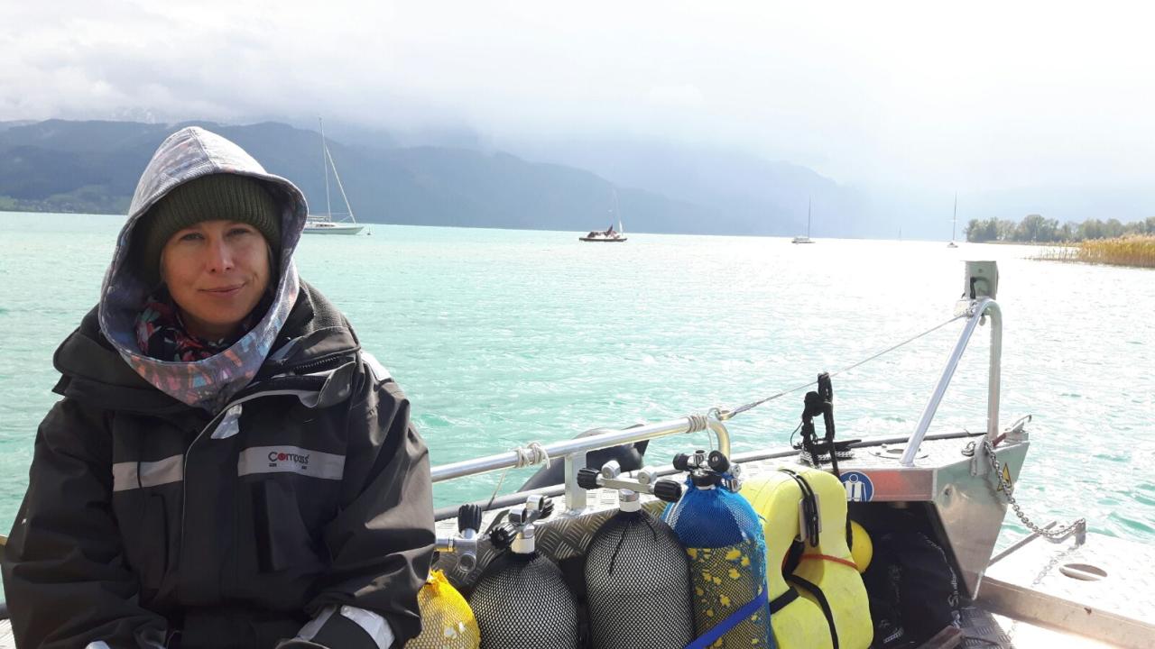 Esther sitzt neben den Tauchflaschen auf dem Boot