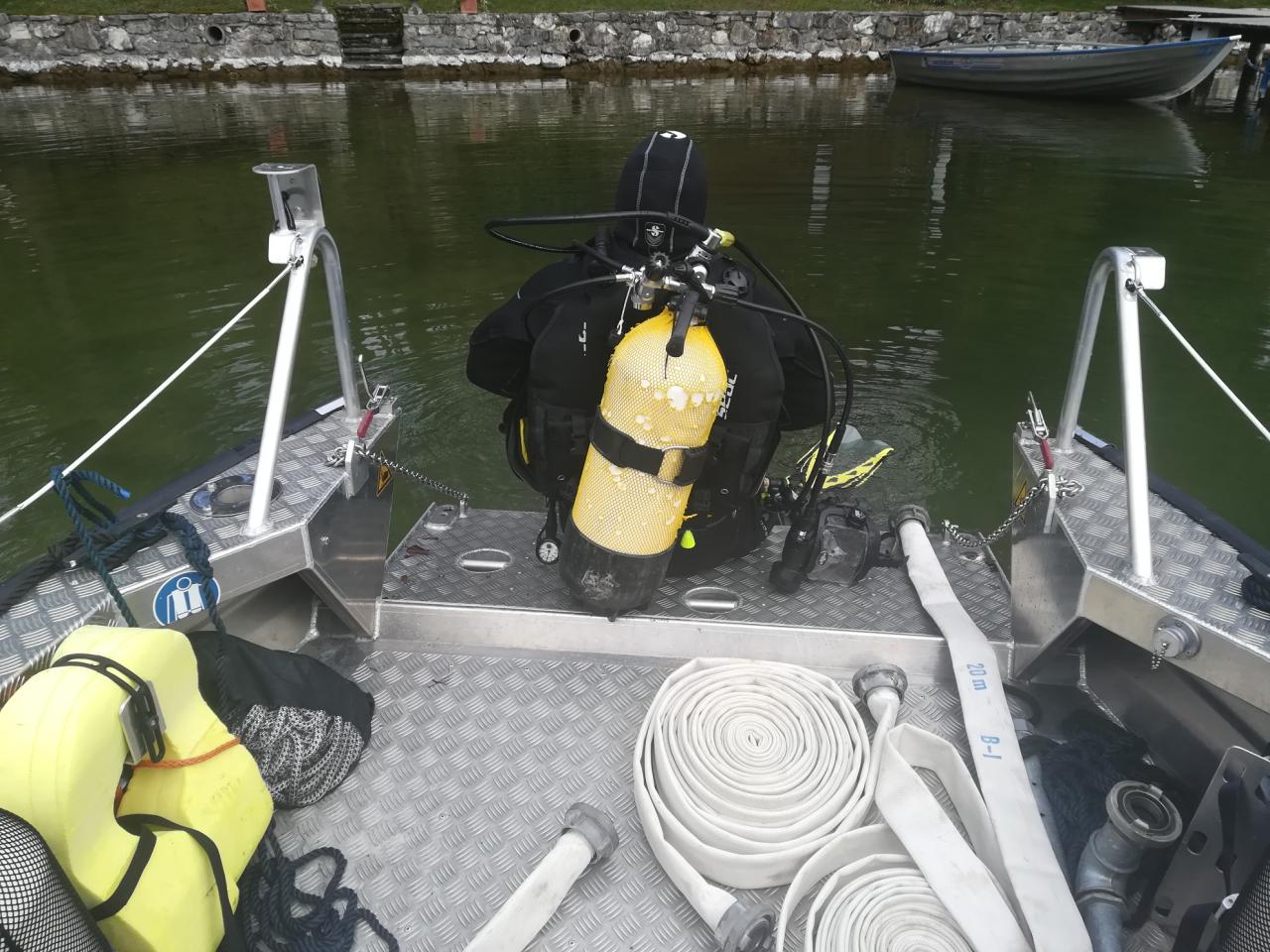 Ein Taucher sitzt am Heck des Bootes, kurz vor dem Einstieg ins Wasser