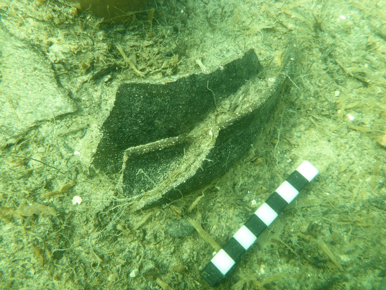Ein Keramikfragment am Seeboden, das für die Dokumentation mit einem Maßstab markiert wurde