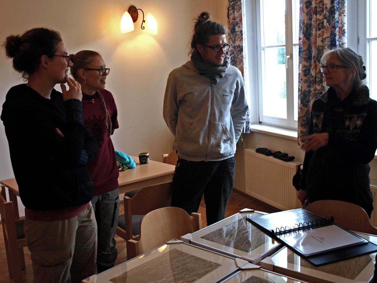 3 Team-Mitglieder lauschen den Erzählungen von Heidi Zenz