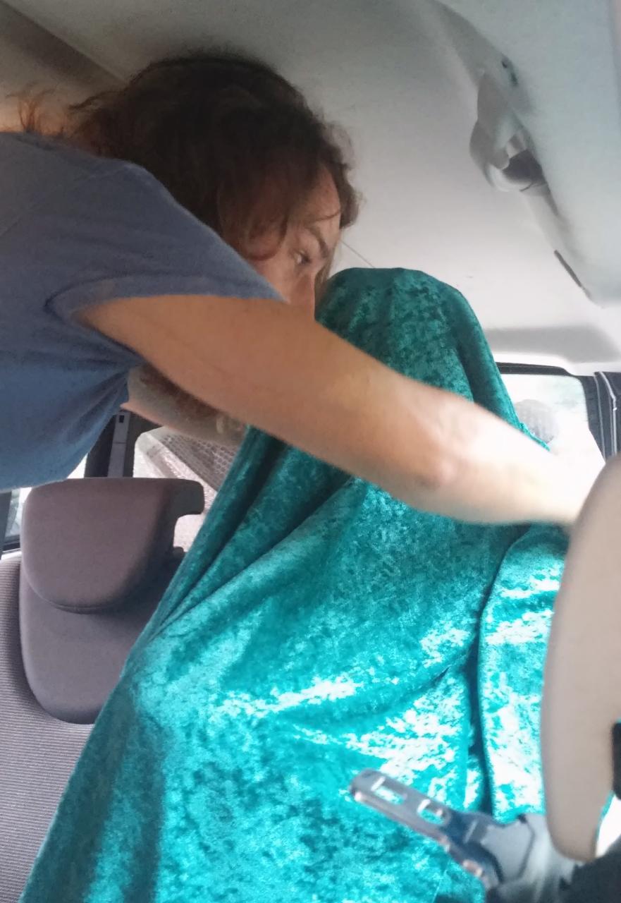 Eine Person wickelt eine andere in einen türkisen Stoff ein