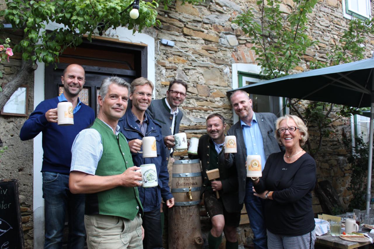 Eine Menschengruppe mit Bierkrügen in der Hand