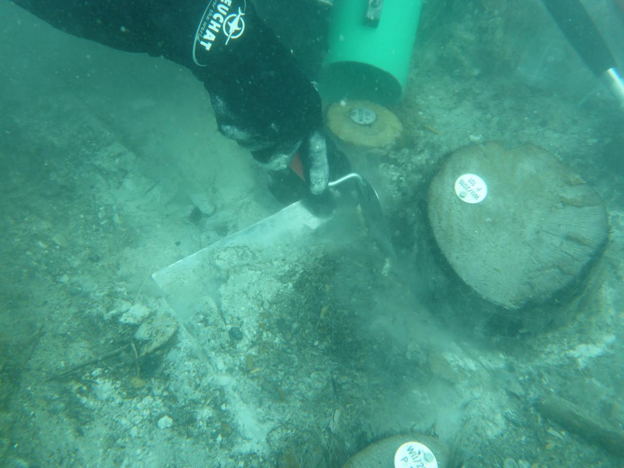 Der Block wird mithilfe einer Kelle aus dem Sediment geborgen