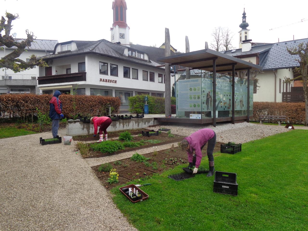 Mehrere Personen bei der Arbeit an den Beeten vor dem Pfahlbaupavillon