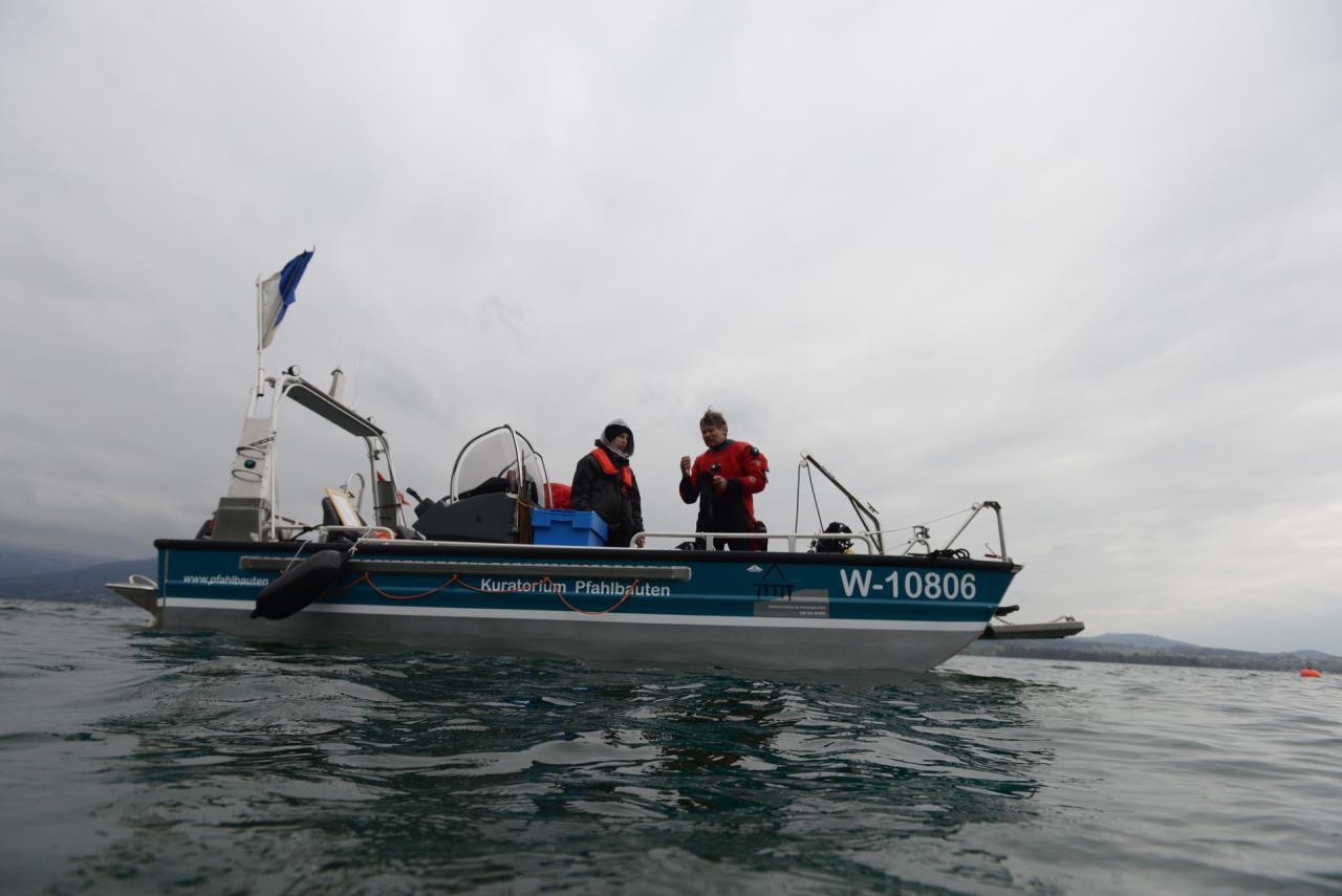 2 Personen auf dem Forschungsboot am Wasser