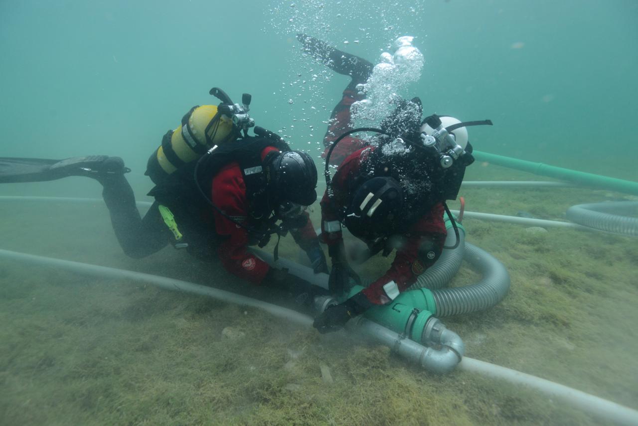 2 Taucher im Unterwasserschnitt bei der Arbeit mit der Dredge