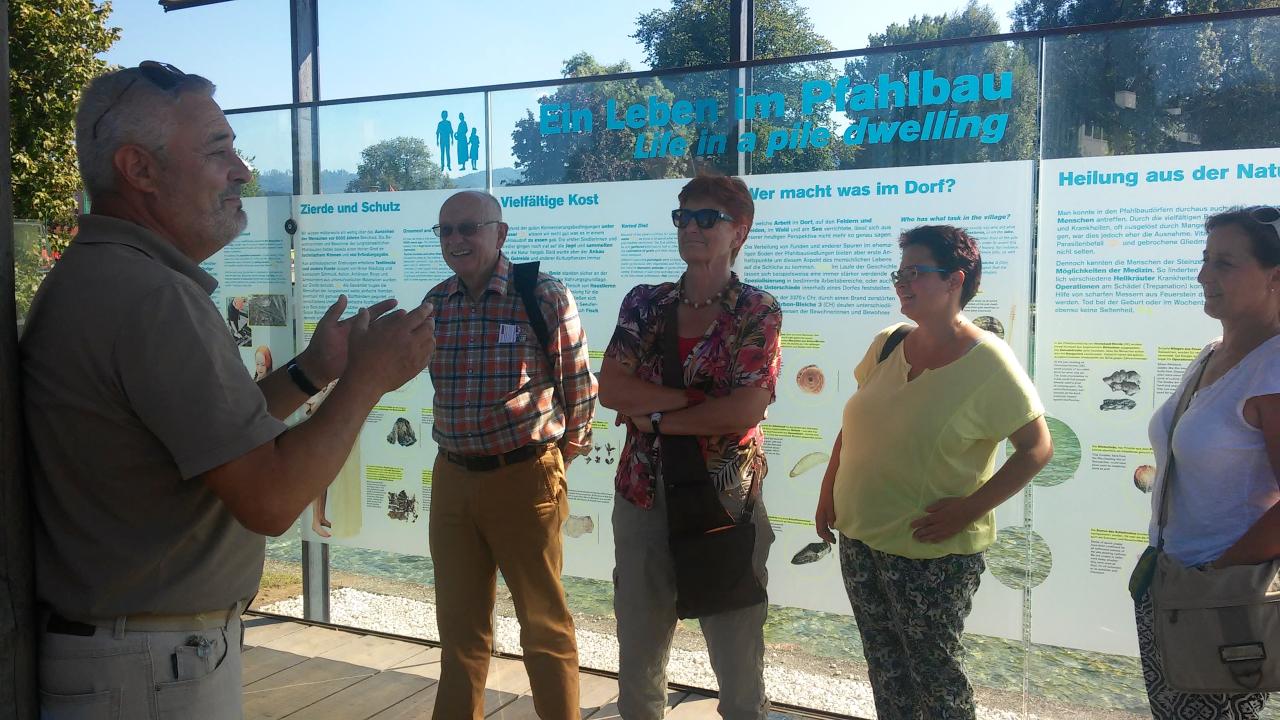 Eine Menschengruppe im Pfahlbau Pavillon in Seewalchen