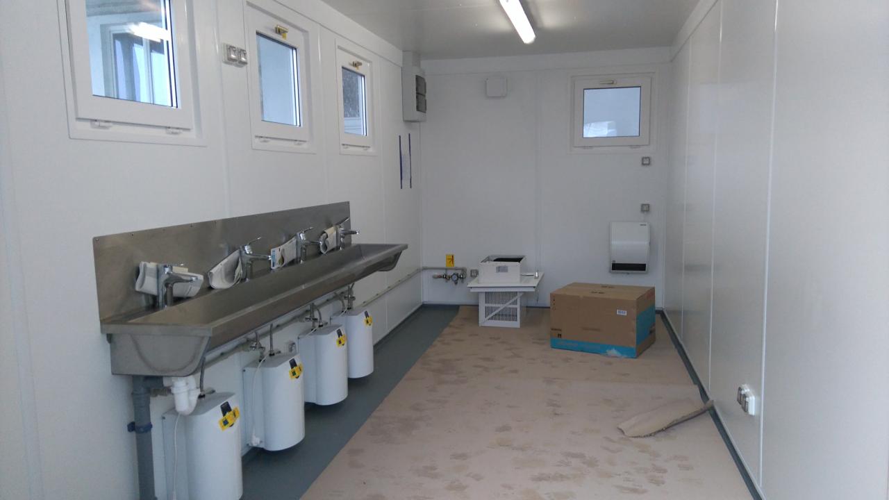 Ein Container von innen mit Waschbecken und Heizungsboilern