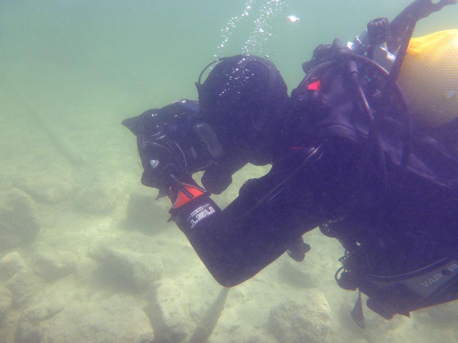 Ein Taucher unter Wasser mit einer Kamera in Händen