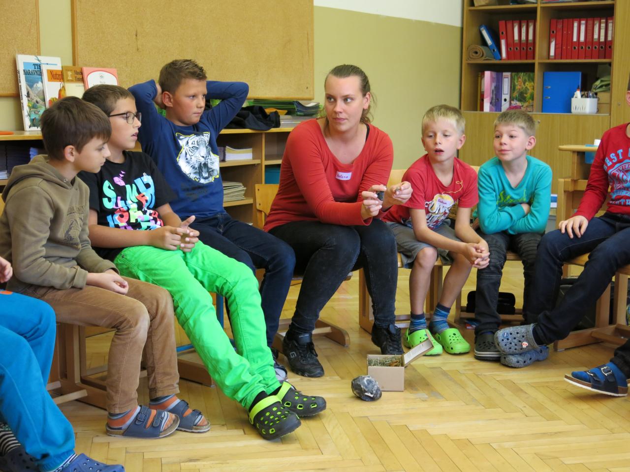 Helena sitzt mit den Kindern im Sesselkreis im Klassenzimmer