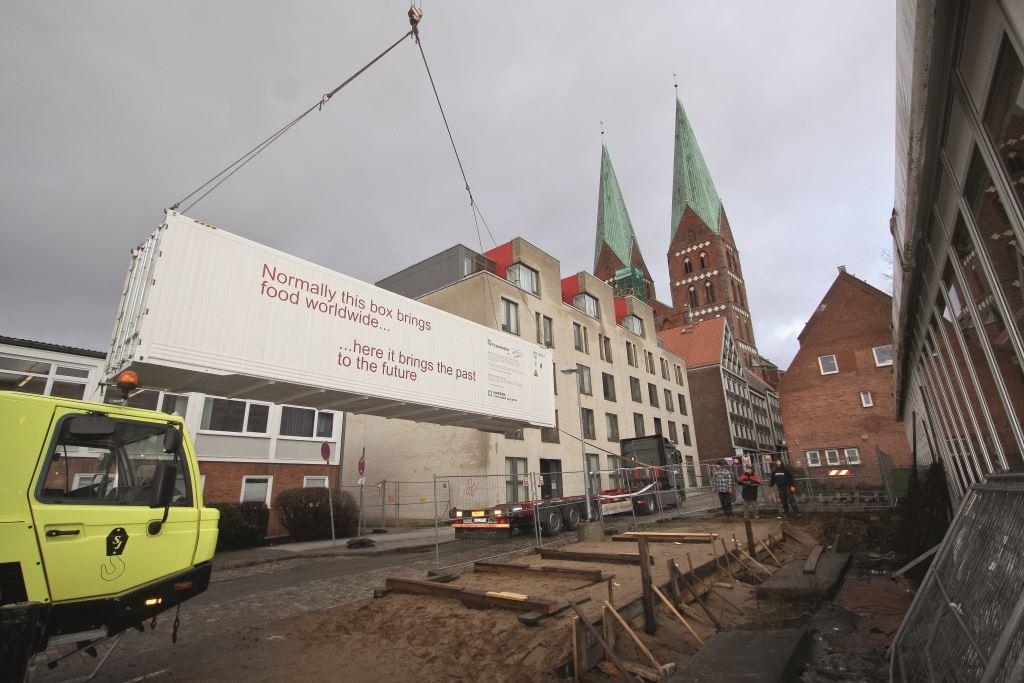 Ein Kran hebt den Container auf den LKW