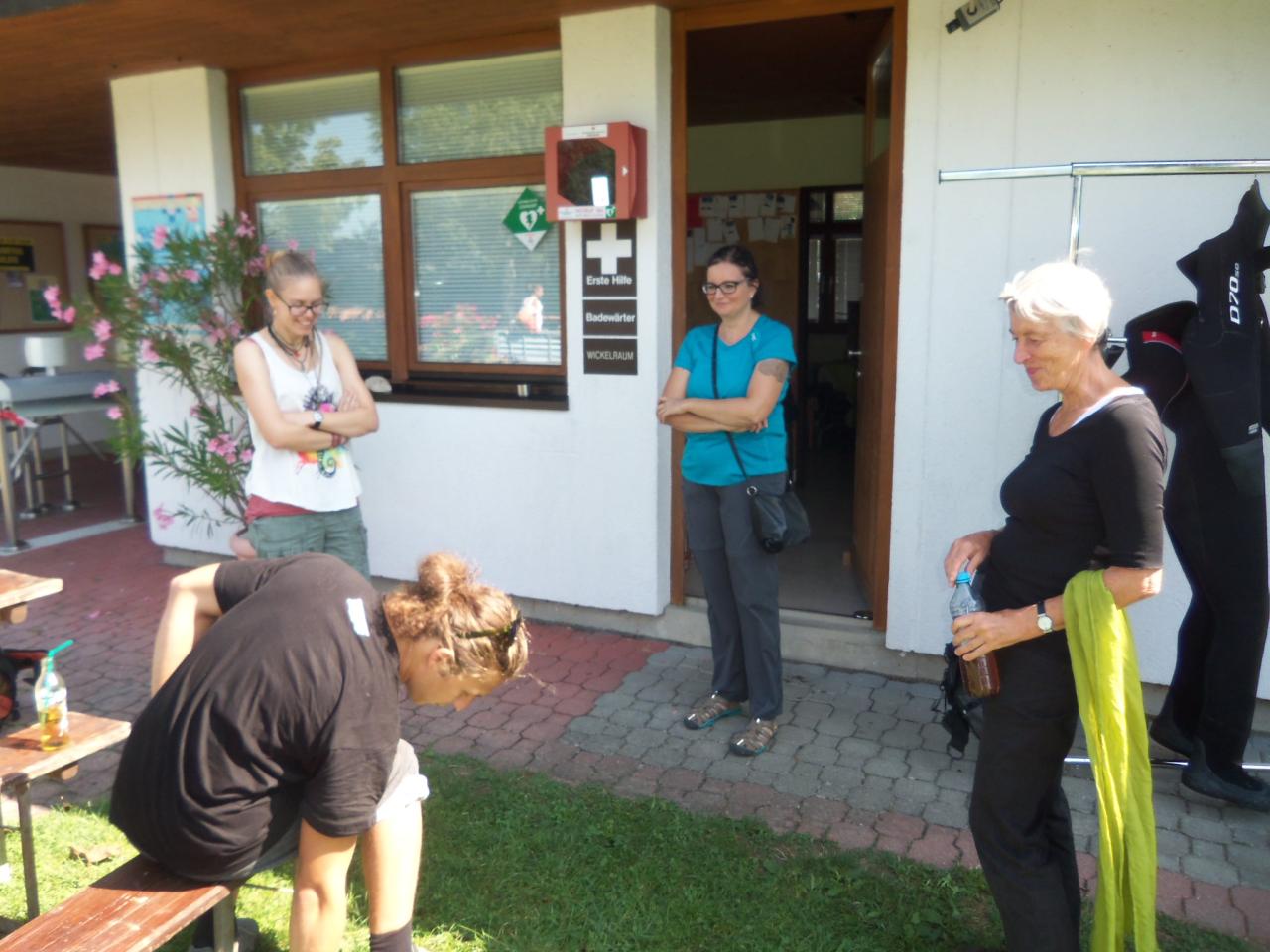 4 Personen stehen im Strandbad und besprechen etwas