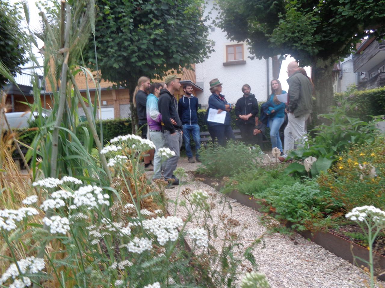 Eine Menschengruppe steht im Steinzeitgarten