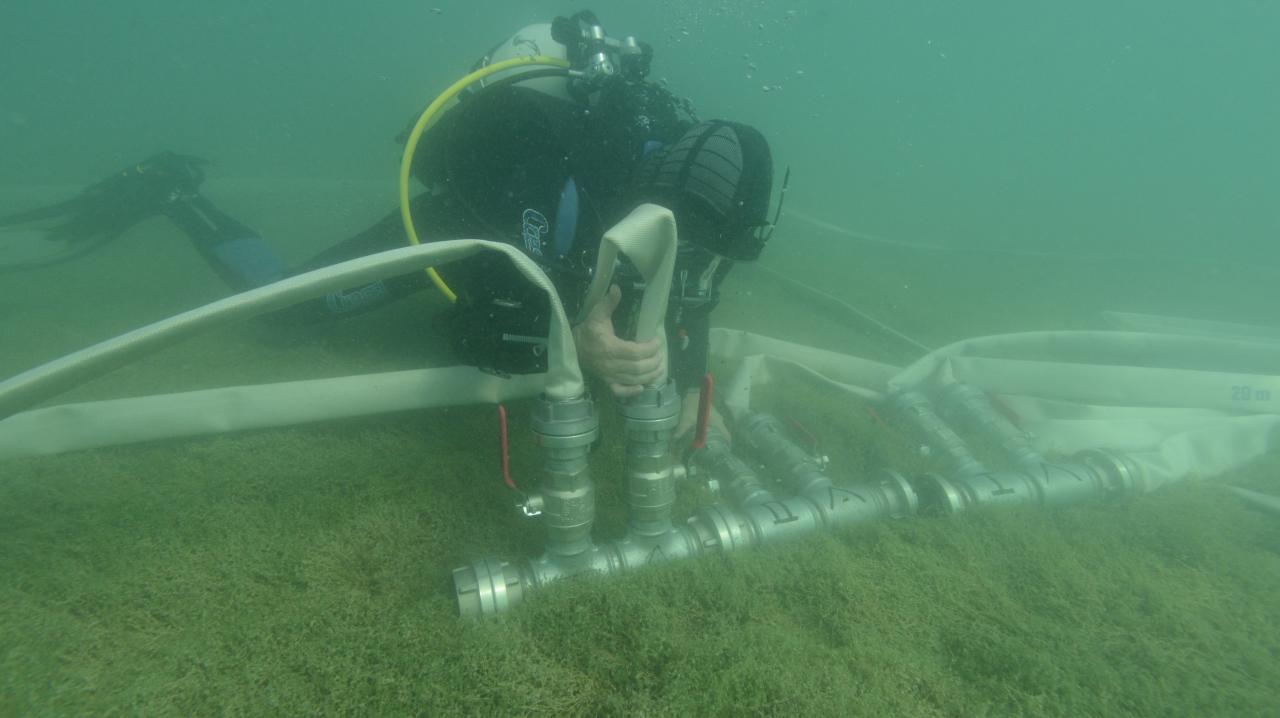 Ein Taucher platziert die Waterdreges am Seeboden