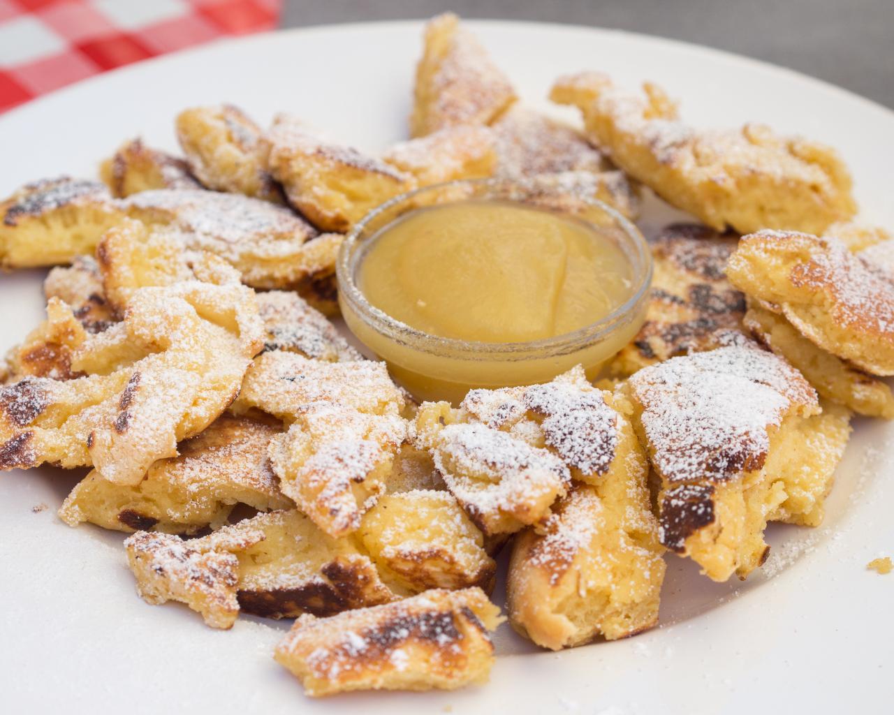 Ein Teller mit Kaiserschmarrn und einem Schälchen Apfelmus in der Mitte