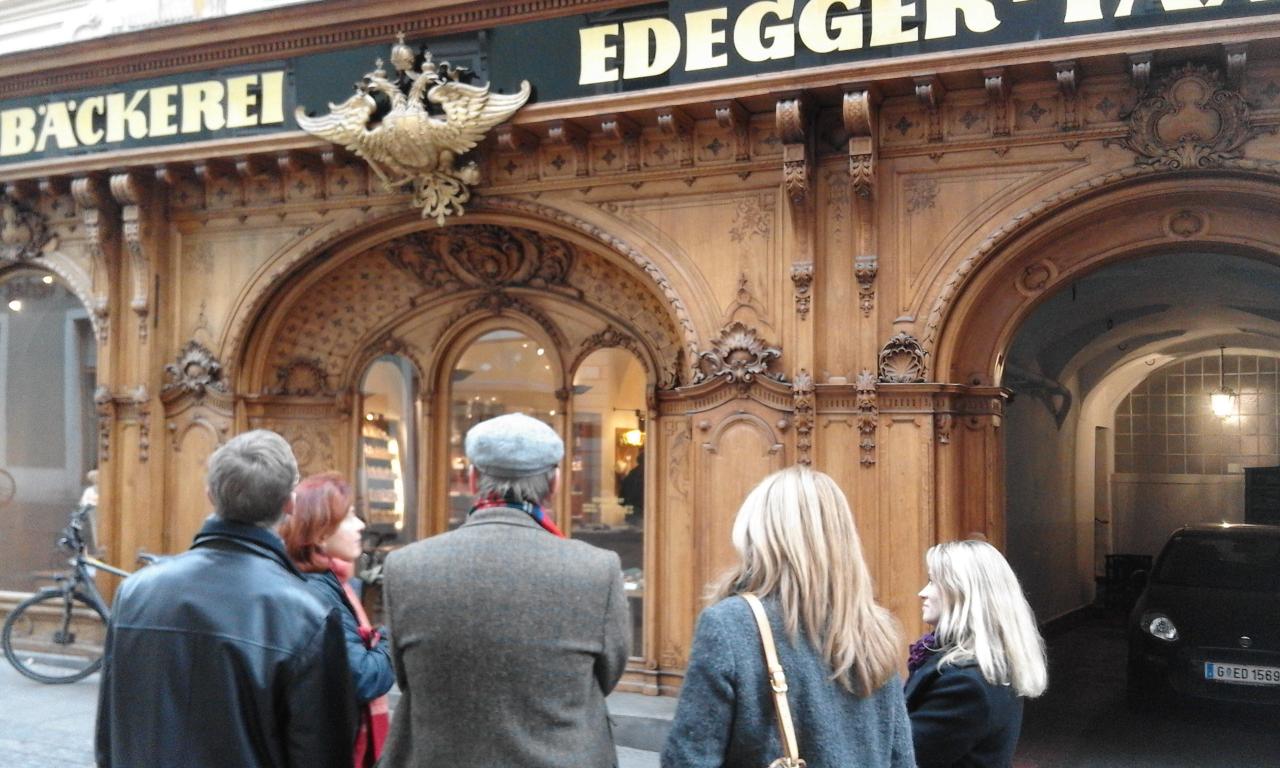 5 Personen betrachten die Fassade der Hofbäckerei Edegger-Tax in Graz