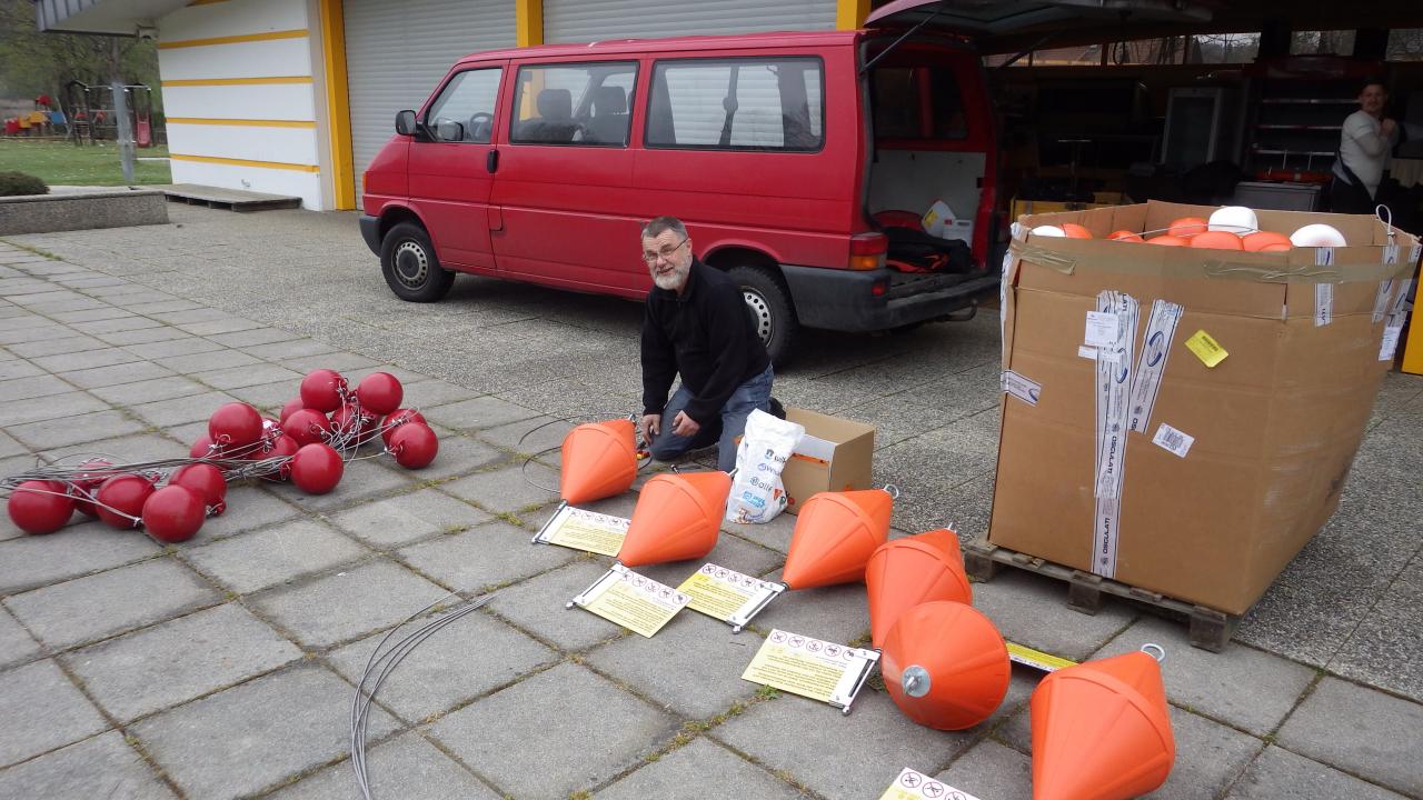 Ein Mann sitzt zwischen roten und orangen Bojen auf einem Parkplatz