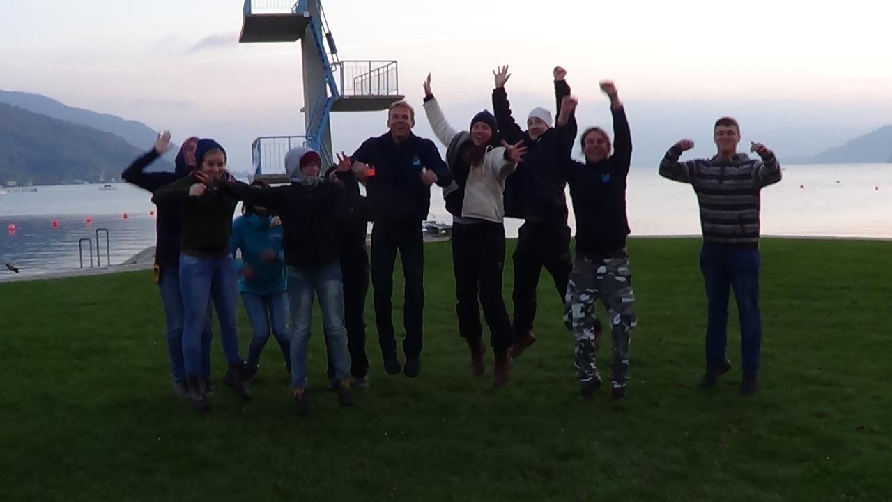 Eine Menschengruppe vor dem Sprungturm in Seewalchen wurde im Sprung fotografiert