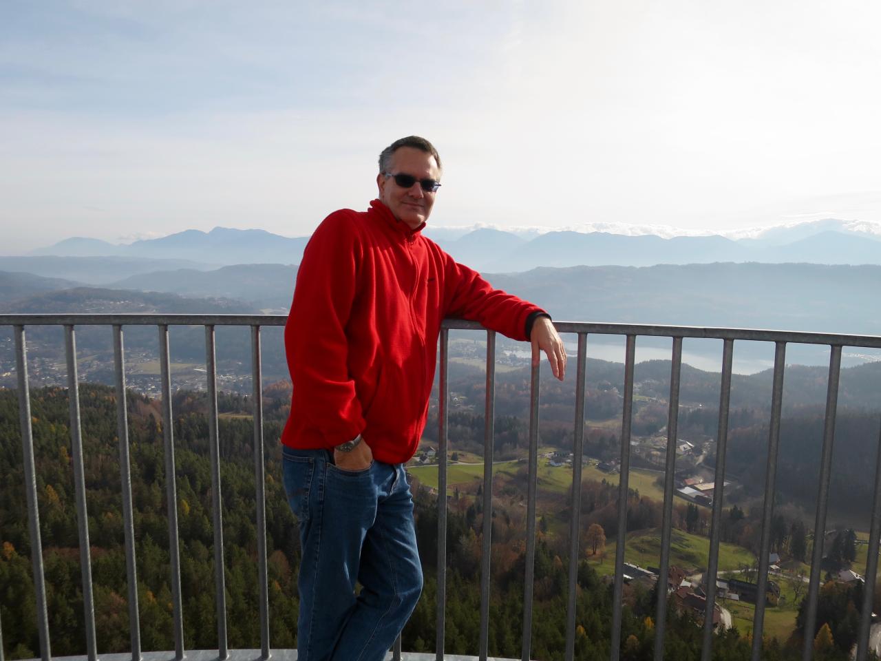 Ein Mann in rotem Pulli steht am Geländer des Turms am Pyramidenkogel