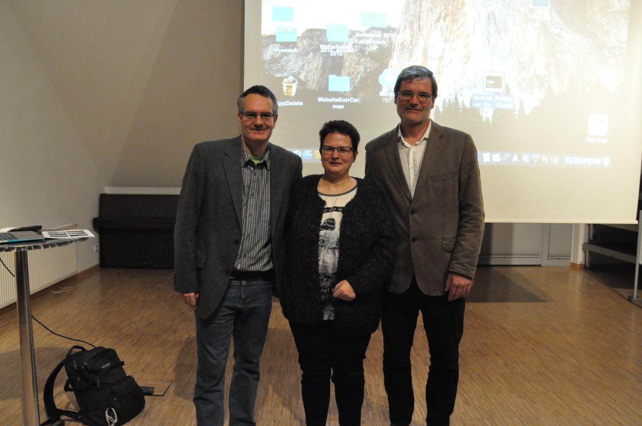 3 Personen stehen vor einer Leinwand