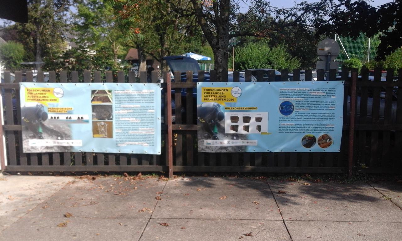 2 Plakate auf einem Zaun montiert
