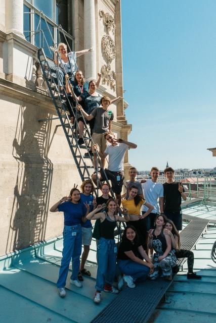 Ein Gruppenfoto einer Schulklasse, die sich vor und auf einer Leiter postieren