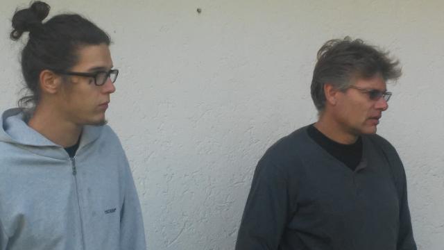 2 Männer blicken vor einer weißen Wand nach rechts