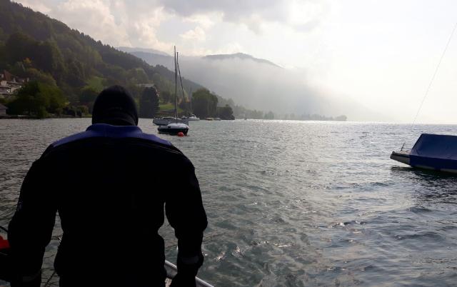 Ein Mann steht vor dem See mit dem Rücken zur Kamera