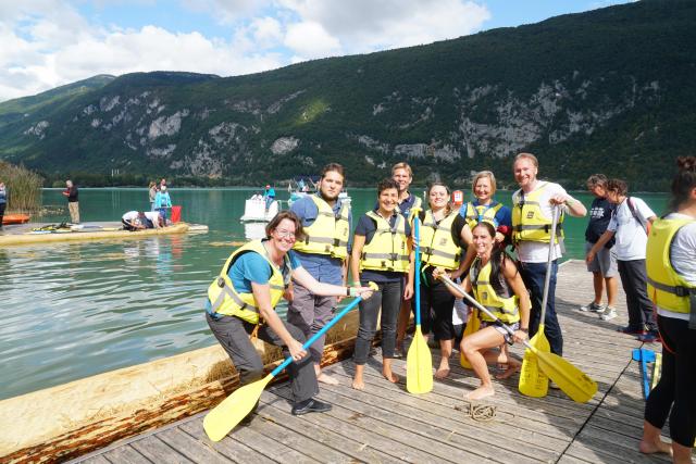 Mehrere Personen in gelben Schwimmwesten stehen auf einem Steg für ein Gruppenfoto